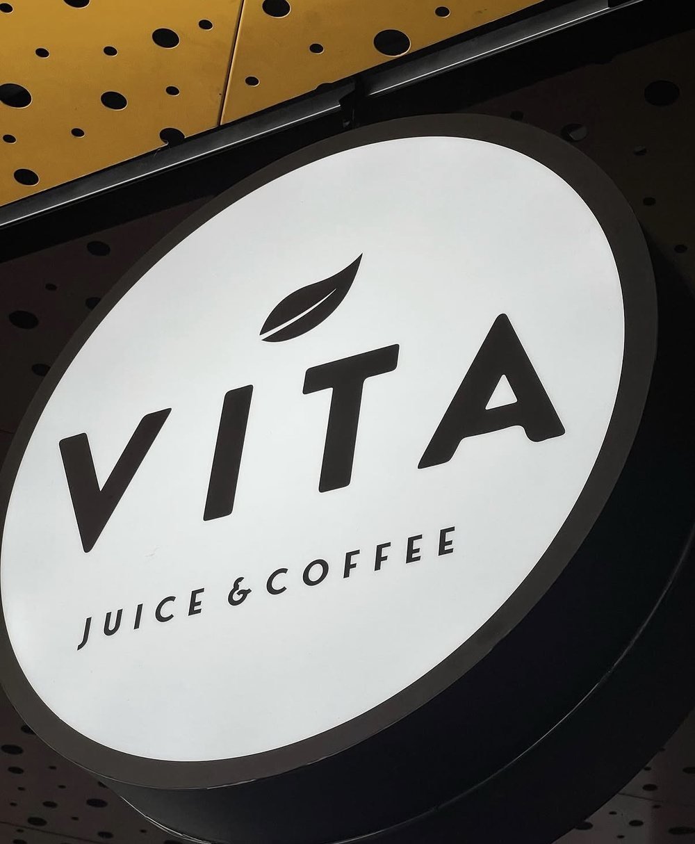Rótulo iluminado de Vita Juice & Coffee en el local
